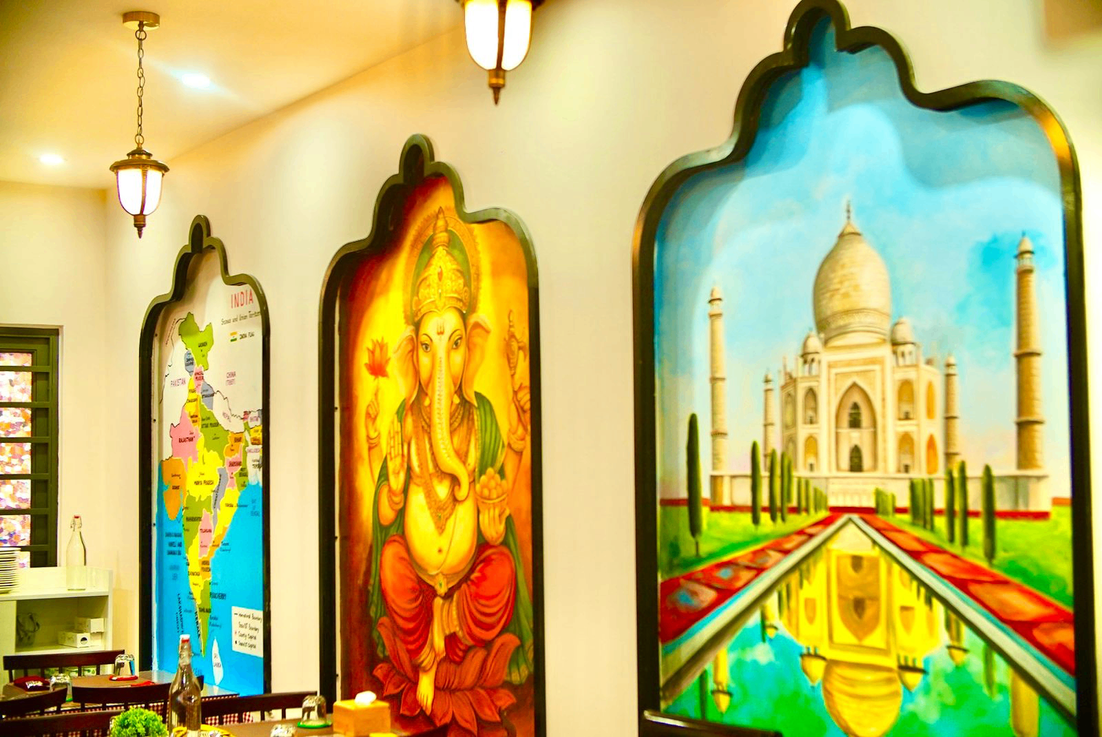 Handmade paintings of India, Ganesha, and the Taj Mahal inside Indian Aroma